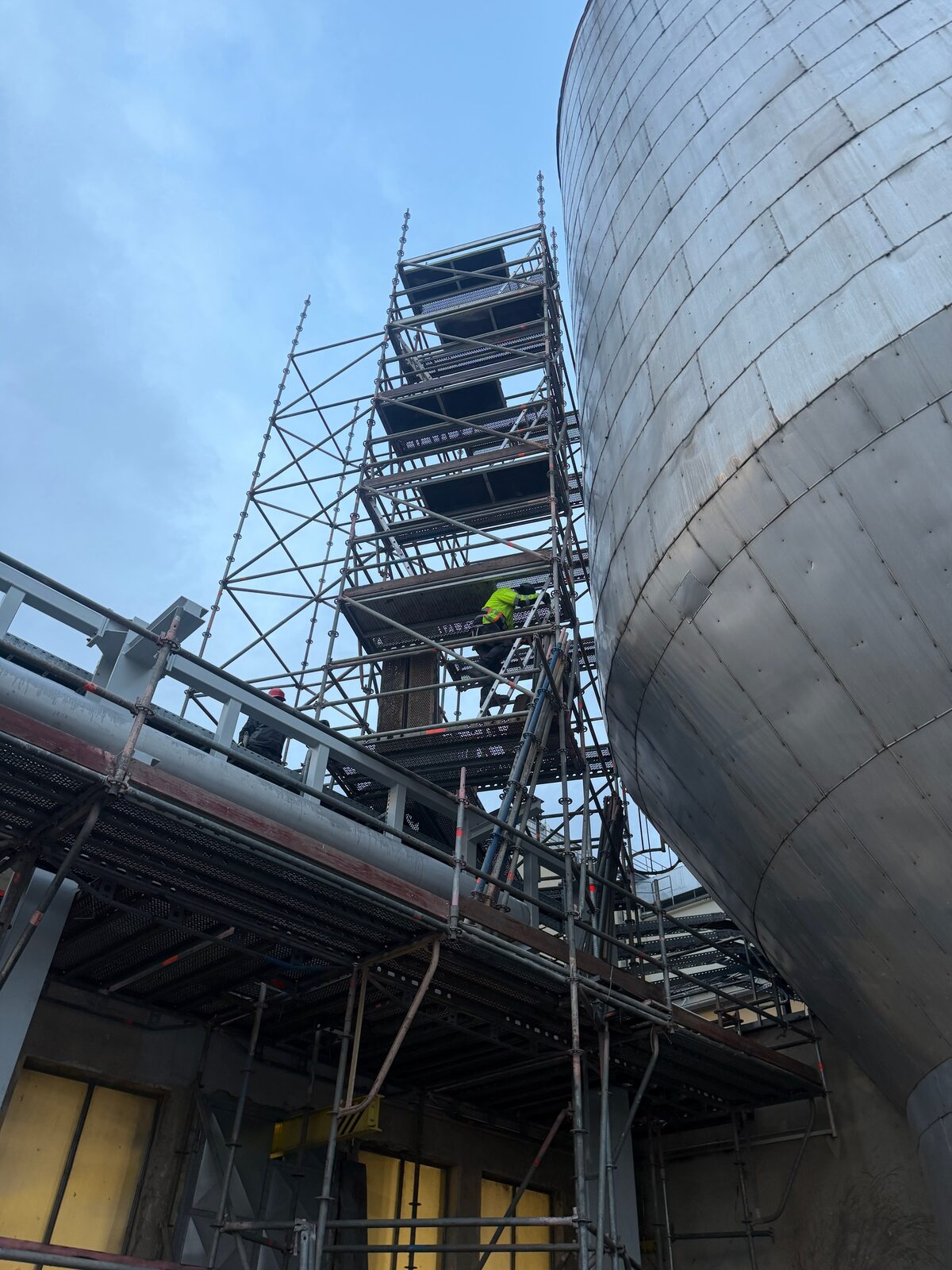 Gerüstturm neben einem Industrietank